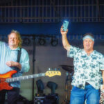 Jay Bourgeois and Leroy St. Pierre of Already Gone encourage the crowd to light up the night with their mobile phones at a performance by the band at Rock The Dock in Kemah, TX.