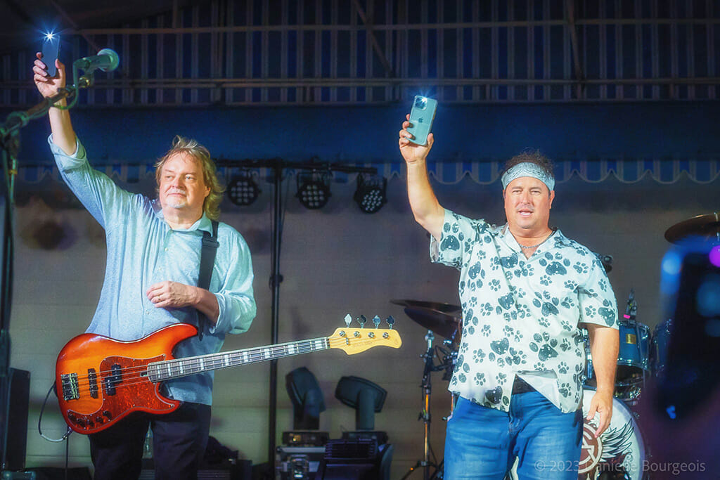 Jay Bourgeois and Leroy St. Pierre of Already Gone encourage the crowd to light up the night with their mobile phones at a performance by the band at Rock The Dock in Kemah, TX.